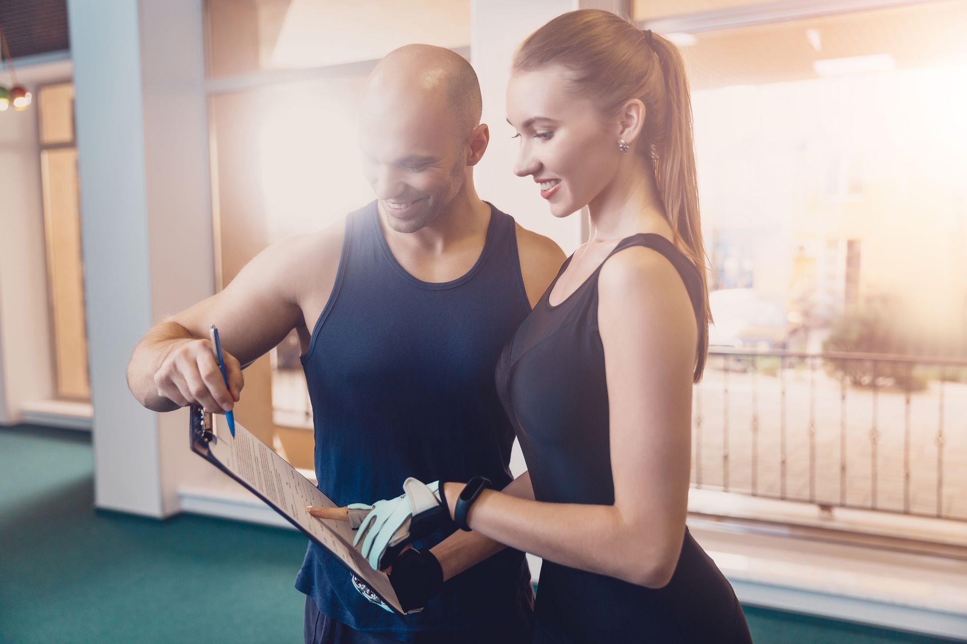 Trainer writes a fitness program training the girl. The program of physical training for effective results when working in the gym. Work on physical labor with an individual trainer in a fitness club.