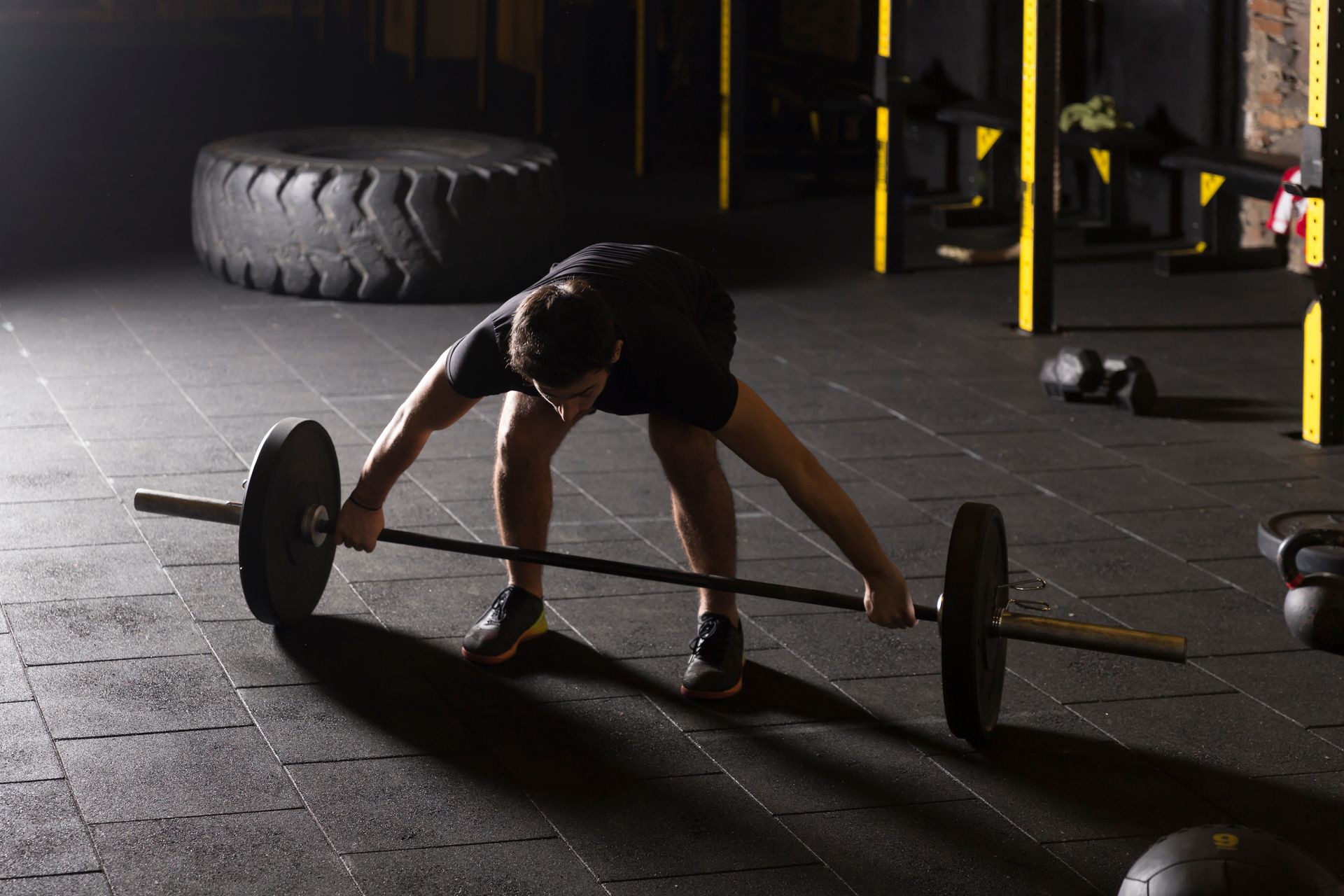 Male athlete practicing snatch movement at the gym.